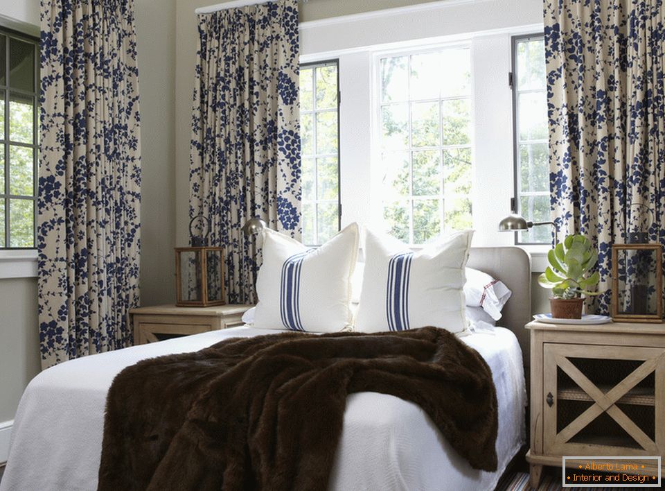 Des fleurs bleues sur les rideaux et des rayures sur les oreillers se combinent harmonieusement à l'intérieur de la chambre