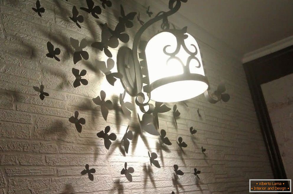 Papillons au mur avec une lampe