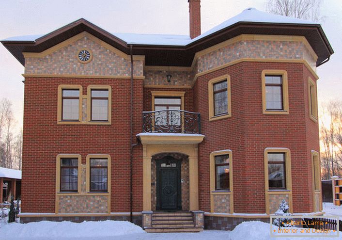 L'architecture insolite d'une maison de campagne en briques est complétée par une décoration en stuc. Les ouvertures de fenêtres et de portes en stuc céramique s'intègrent harmonieusement dans le style général de l'extérieur. 
