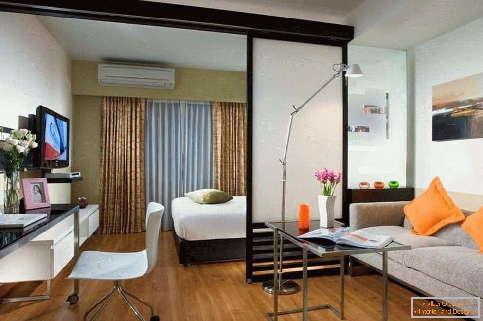 Chambre et salon dans une pièce séparés par une cloison semi-transparente