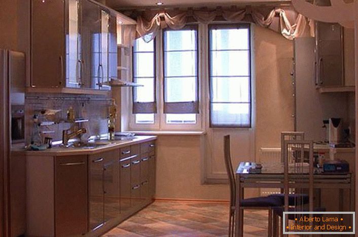 Un ensemble de cuisine spacieux avec des armoires suspendues dans des tons beige clair semble attrayant et exquis. Au lieu d'un garde-manger, le concepteur a fabriqué une niche, où, par commodité, un réfrigérateur a été placé.