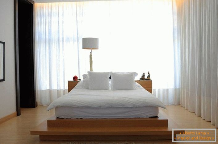Le lit ressemble à un grand lit en plumes, situé sur une haute passerelle de bois. Les rideaux en tissu doux, translucide et volant rendent l'atmosphère dans la chambre romantique et relaxante. 
