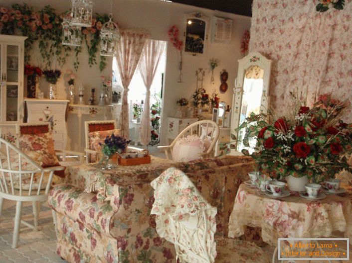 Des fleurs dans le vase, sur le mur et même sur la tapisserie du canapé. Hall dans le style de la Provence dans une petite maison de campagne du sud de la France.