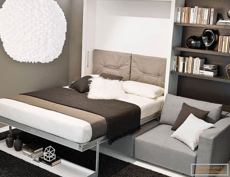 Un lit caché dans un placard sur un canapé dans une petite pièce
