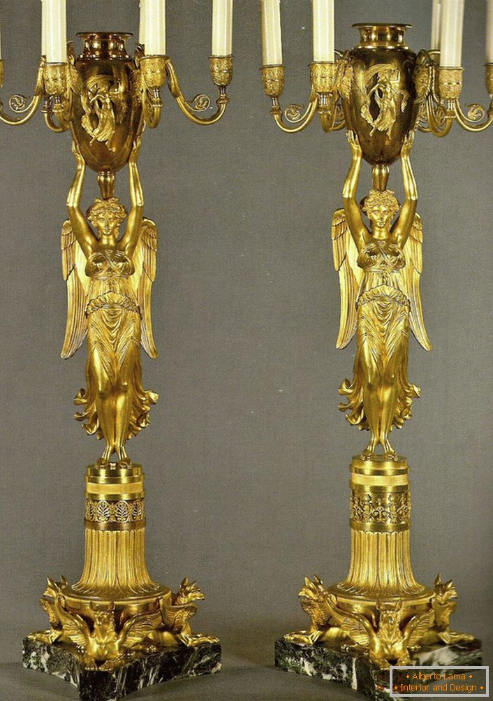 Une paire de candélabres dorés identiques orne la chambre dans le style baroque. 