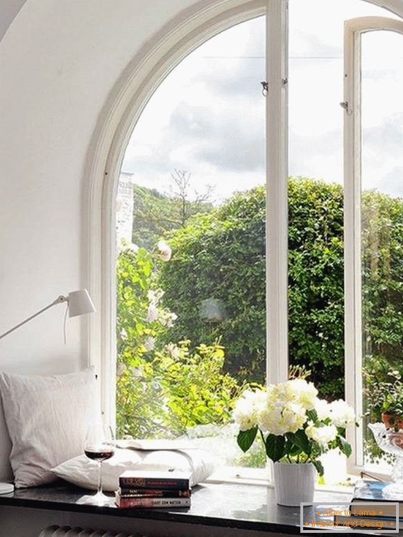 Décoration de fenêtre avec des oreillers, des livres, des fleurs