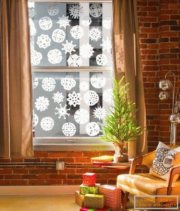 Couper et coller des flocons de neige sur les fenêtres pour la nouvelle année