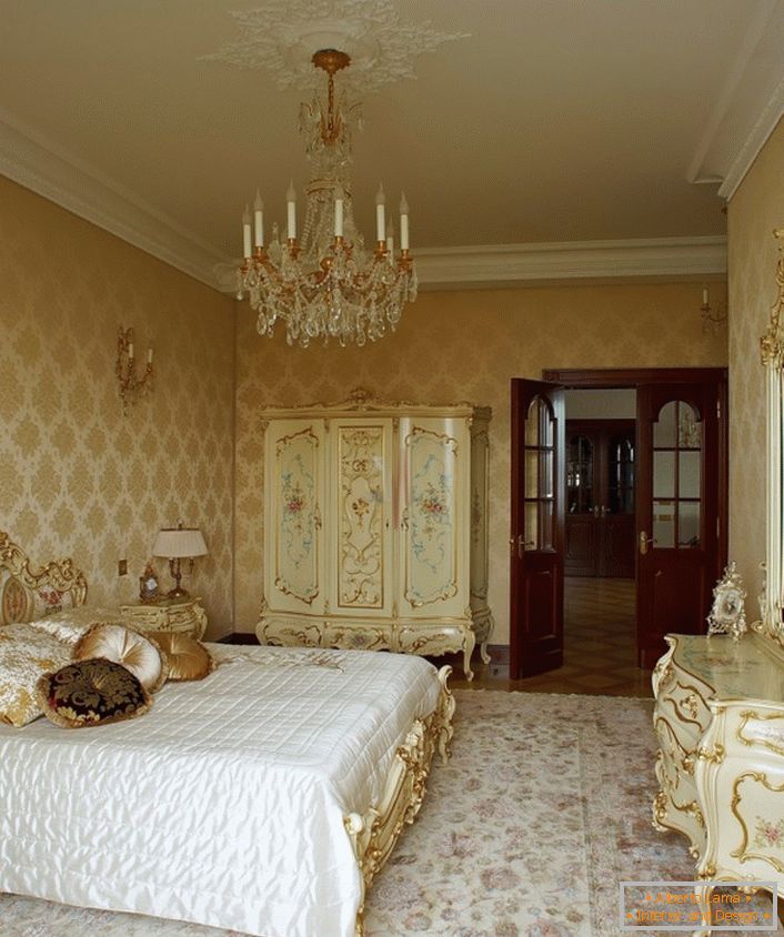 Le lustre chic et le plafond en stuc se marient harmonieusement avec les meubles en bois aux couleurs dorées. 