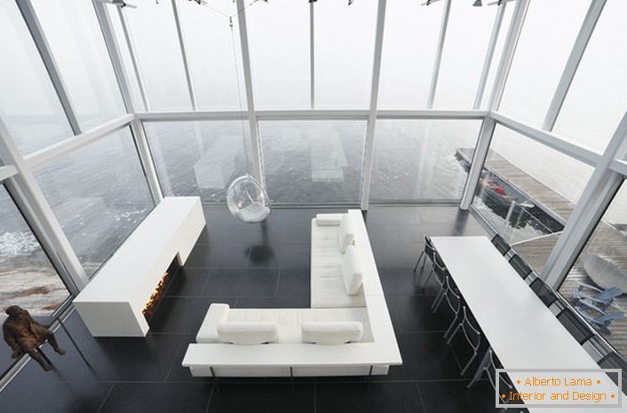 Design laconique du salon dans un style minimaliste. Un meuble intéressant est une chaise suspendue à un haut plafond.