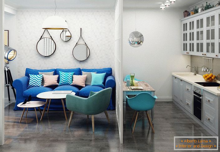 Le canapé bleu foncé contraste avec la finition légère. Un exemple de conception réussie d'un petit appartement d'une pièce.