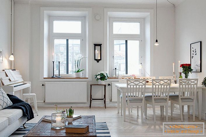 L'élégant salon est divisé en un coin salon et un coin repas. Conformément au style scandinave, les murs de la salle sont décorés en blanc.