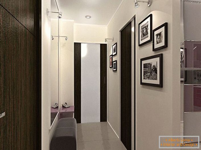 Solution de conception pour un couloir étroit. La décoration dans des couleurs contrastées de blanc et de marron foncé, non seulement est élégante, mais rend également la pièce plus visuelle.