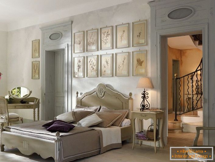 Conformément aux traditions du style français pour la chambre à coucher a été choisi mobilier léger laconique de bois. Un détail intéressant est un collage de photos au-dessus de la tête du lit.