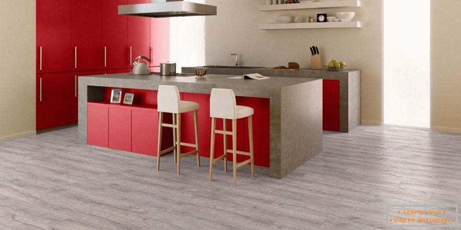 La combinaison de sols gris, murs beiges et meubles rouges dans la cuisine