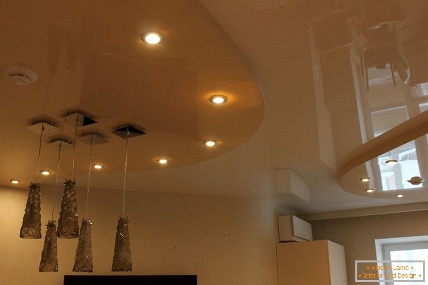 Plafond tendu à deux niveaux en PVC dans le salon de l'appartement citadin. L'éclairage conceptuel est un bon geste de conception.