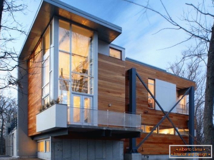 Les murs en bois de la maison sont de style high-tech avec des fenêtres panoramiques en plastique élégantes.