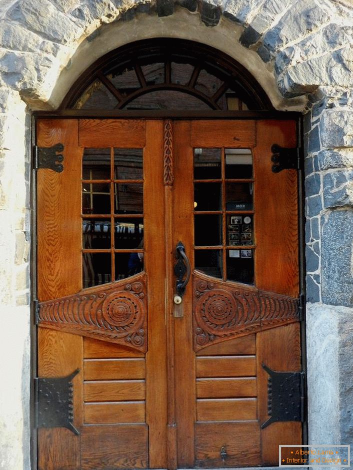Les portes de style Art Nouveau ornent la porte d'entrée d'un chalet avec une façade en pierre naturelle. 