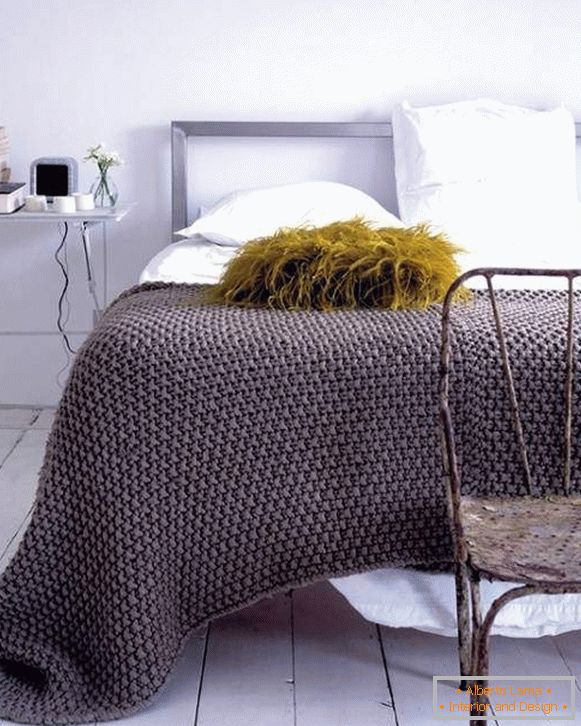 Plaid tricoté sur le lit avec vos propres mains en couleur à la mode
