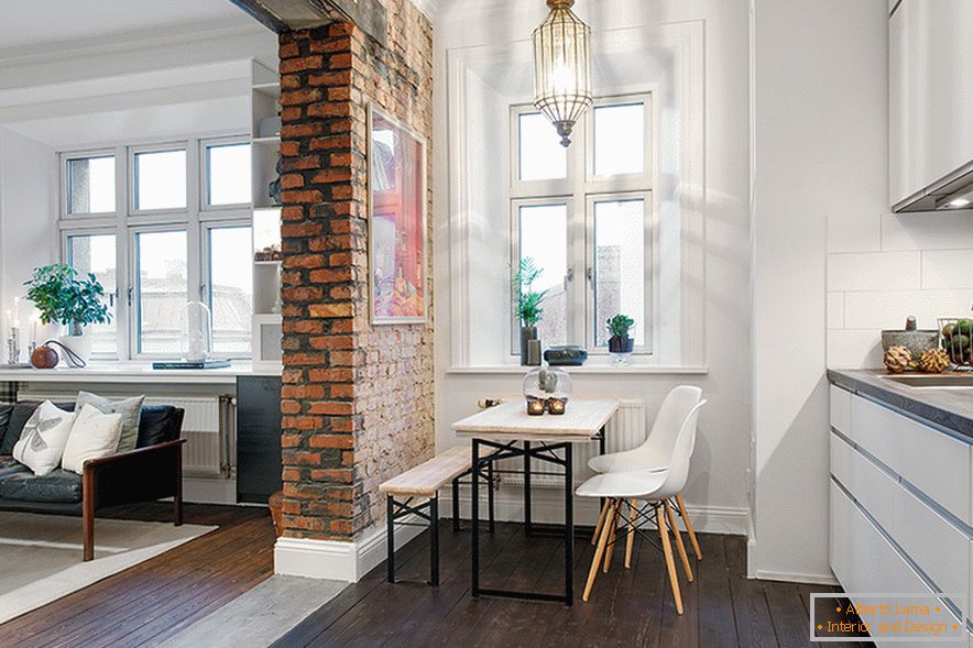 Une arche de maçonnerie en briques non zonées divise l'espace en un salon et une cuisine