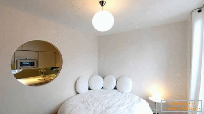 Le vide dans le mur de la forme ovale fait d'un petit appartement un studio de luxe.
