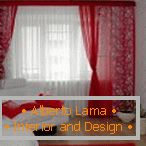 Rideaux rouges, oreillers et tapis en combinaison avec des murs et des meubles blancs