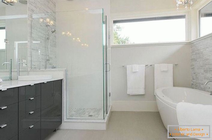 Une spacieuse salle de bains moderniste avec le bon éclairage est décorée par le célèbre designer français. 