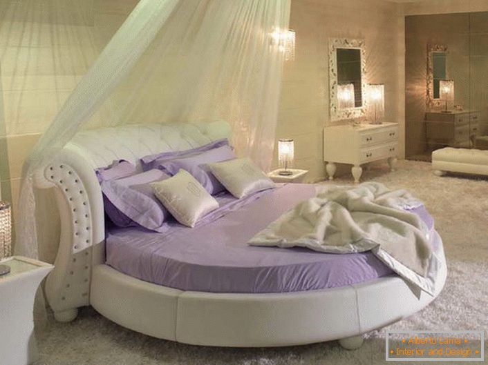 Un lit doux rond original sous un auvent translucide.