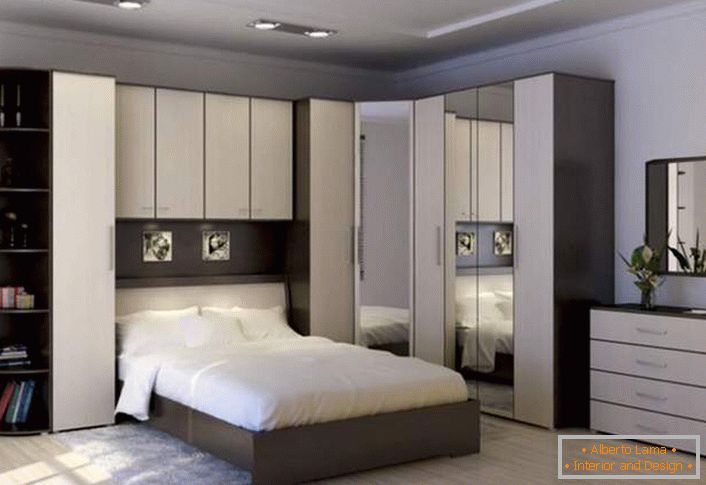 Mur d'angle fonctionnel pour la chambre. L'espace correctement conçu reste spacieux et non encombré. Un endroit pour économiser permet des casiers articulés au-dessus du lit.