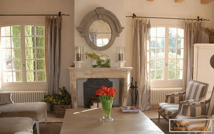 Salon dans le style du pays avec des notes de romantisme. Belles grandes fenêtres et meubles de maison confortables. Excellente idée pour une grande famille.