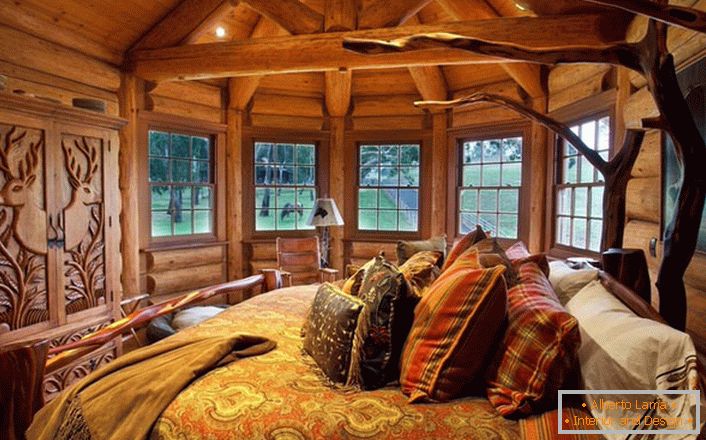 Une des chambres de la maison près du lac est faite dans le style de la campagne. Décoration en bois Le mobilier massif et les éléments de décoration sont sélectionnés dans les meilleures traditions de style.