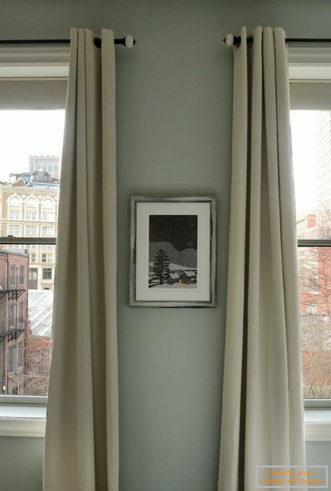 Intérieur d'un petit appartement: longs rideaux aux fenêtres