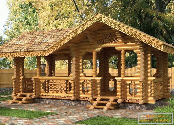 Un kiosque de conte de fées dans le style d'un chalet est construit avec un faisceau lumineux. Au gazebo, dirigez les chemins des carreaux de granit.