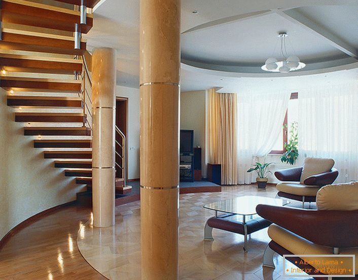 Un salon spacieux et lumineux sous un escalier dans un appartement à deux niveaux. 