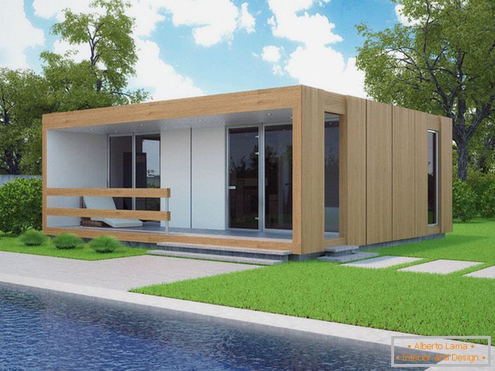 Une petite maison modulaire avec une piscine dans la cour. Le design élégant d'une maison en cours de construction donne rapidement une apparence organique à l'arrière-plan d'une pelouse courte.