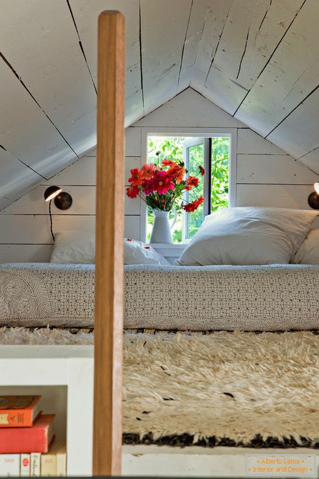 Chambre sous le plafond dans une petite maison confortable