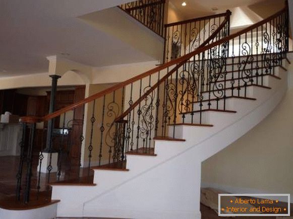 Un bel escalier en béton avec des rails forgés à l'intérieur d'une maison privée