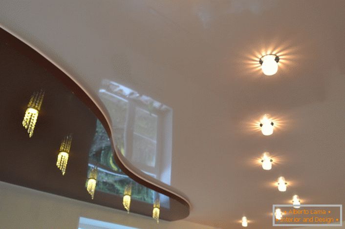 Chemins d'éclairage originaux conçus pour un plafond à deux niveaux. Sous l'insert de cerise noire, l'installation d'un comptoir suggère.