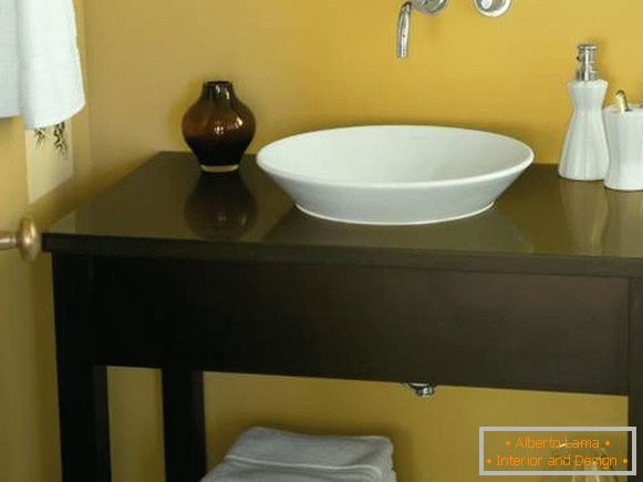 Une table de trottoir sous un évier dans une salle de bain les mains