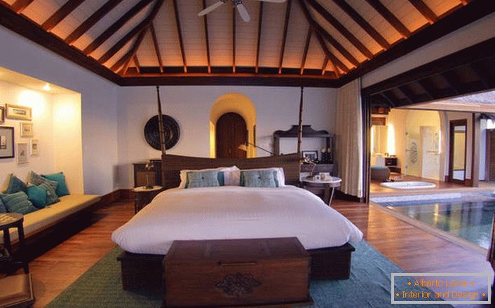 Les meubles en bois massif de bois sombre semblent luxueux et élégants. Le lustre de plafond est sélectionné dans les meilleures traditions de style.