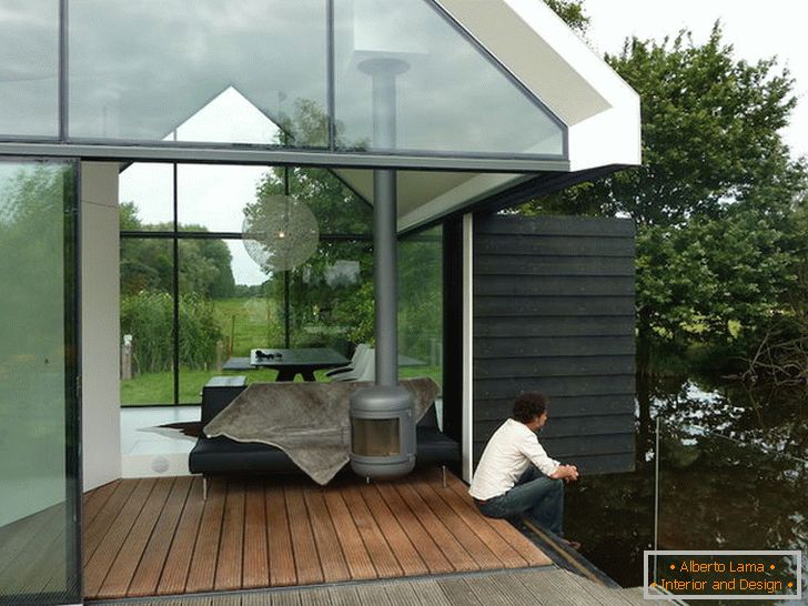 Terrasse d'une petite maison de verre au bord du lac en Hollande