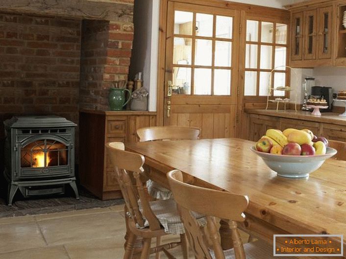 Une cheminée de cheminée avec une niche de la cheminée s'intègre parfaitement à l'intérieur général de la cuisine dans le style du pays.