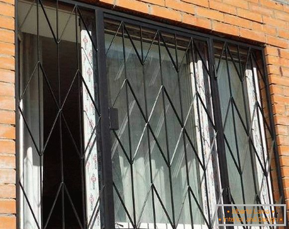 Grilles pivotantes en métal sur les fenêtres du rez-de-chaussée