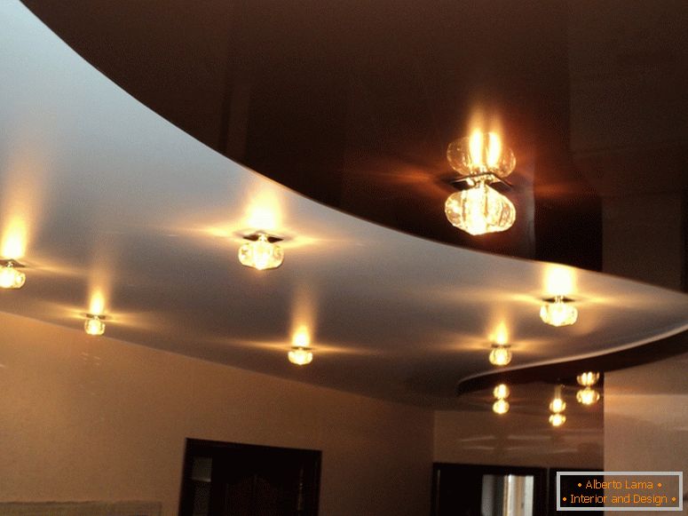 Un plafond exquis pour un salon spacieux est particulièrement pertinent dans des conditions d'éclairage insuffisant.