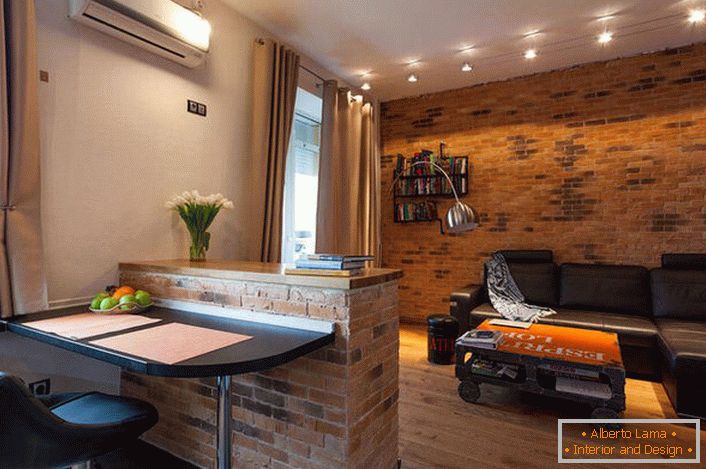Dans la conception d'un appartement d'une pièce dans le style loft, des couleurs chaudes de beige sont utilisées. Dans un intérieur familial et chaleureux - une solution inhabituelle pour le loft.