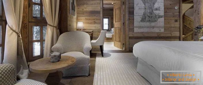 Dans la chambre, dans le style du chalet alpin, se trouve un lit qui ressemble à un lit de plumes aéré.