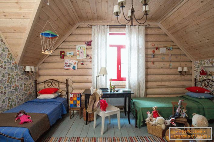Chambre d'enfants dans un style campagnard à l'étage mansardé. Un plafond en bois et un mur avec une grande fenêtre complètent parfaitement le style campagnard.