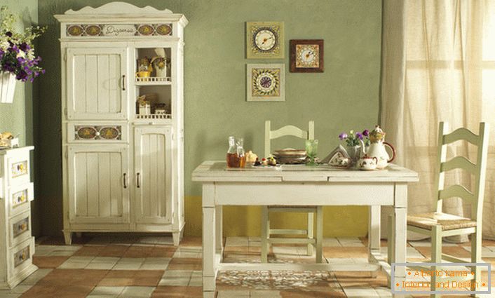 Une cuisine confortable dans un style campagnard est exécutée dans la lumière blanche et olive douce. Combinaison parfaite de couleurs pour le style rustique.