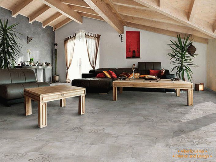 La couverture des sols et des murs imite une finition rugueuse. Les plafonds en bois sont combinés en une composition commune avec des meubles. Une variation chanceuse du style loft dans le salon.
