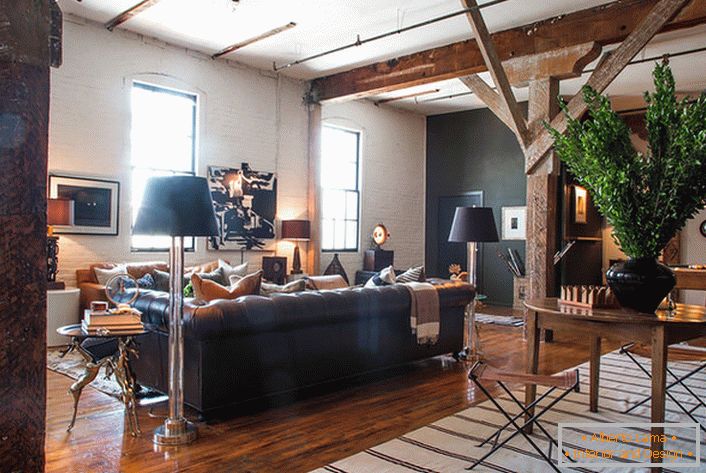 Une atmosphère créative règne dans le salon dans un style loft. Des accents lumineux rendent la pièce confortable et chaleureuse.