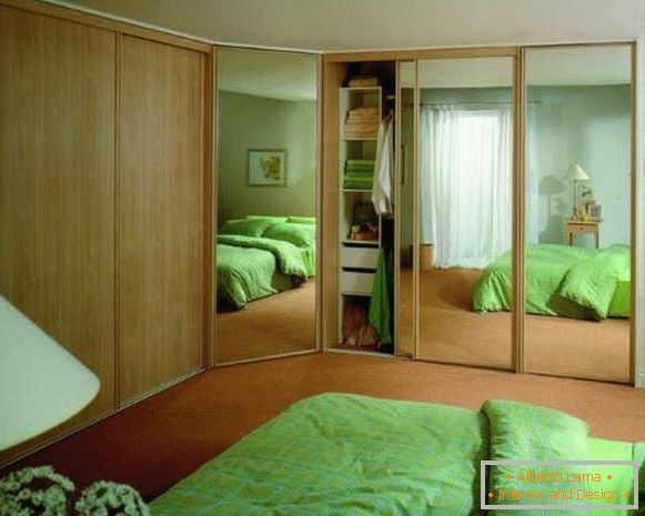 Armoire encastrée d'angle dans la chambre avec portes miroir